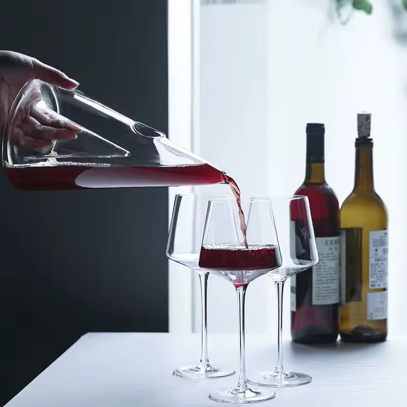 CrystalPyramid™ wine decanter pouring red wine elegantly into glasses.