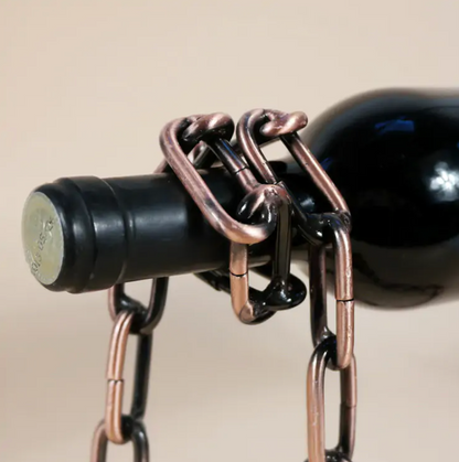 FlottaVin porte-bouteille magique en chaîne de fer suspendant une bouteille de vin noire.