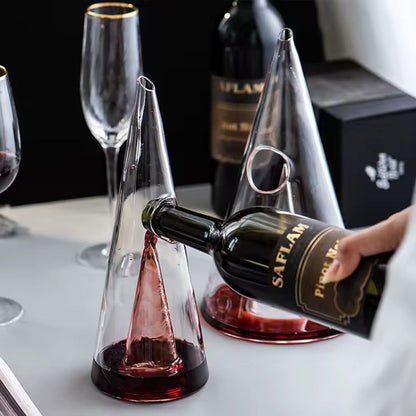 Transparent CrystalPyramid™ wine decanter in pyramid shape with red wine being poured.