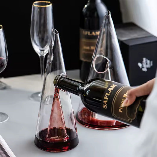 Transparent CrystalPyramid™ wine decanter in pyramid shape with red wine being poured.